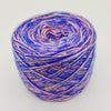 A ball of variegated yarn with a color-changing pattern shifting between vibrant blue and soft pink, photographed on a clean white background.