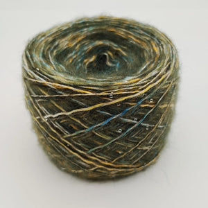 A single ball of variegated yarn with a textured, fuzzy appearance, featuring a blend of olive green, mustard yellow, and dark brown threads, photographed on a clean white background.