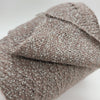 Close-up of SIA Craft Mind Yarns fine boucle Merino yarn showcasing its soft, textured wool fiber in natural tones.